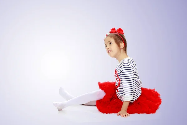 Niña con falda roja e inclinada sobre su cabeza . —  Fotos de Stock