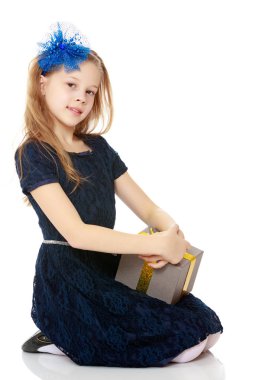 Elinde bir hediye ile sevimli küçük kız.