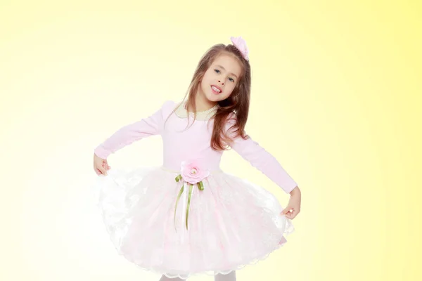 Elegant liten flicka i en rosa klänning. — Stockfoto