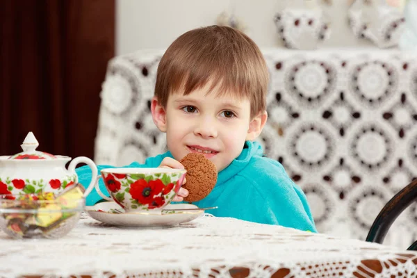 Мальчик пьет чай за столом. . — стоковое фото