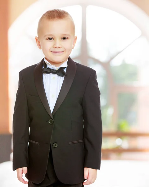 Menino na moda em um terno preto com uma gravata . — Fotografia de Stock