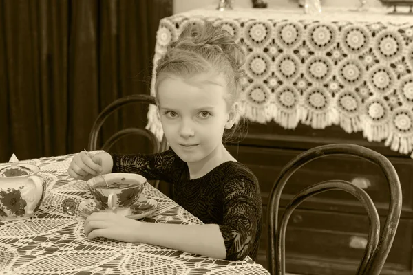 Mooi meisje, drinken van thee op de tafel. — Stockfoto