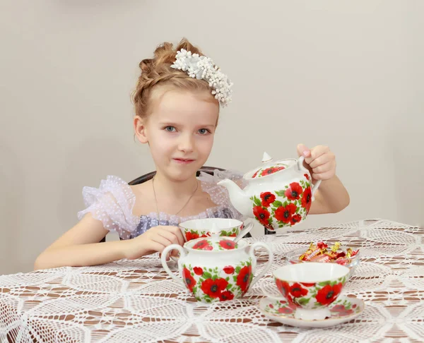 Schattig klein meisje thee drinken bij de oude tabel. — Stockfoto