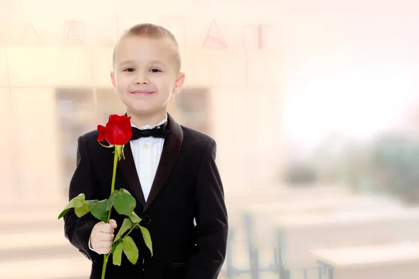 Menino com uma flor de rosa . — Fotografia de Stock