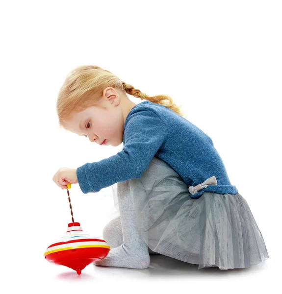 Girl playing humming top. — Stock Photo, Image