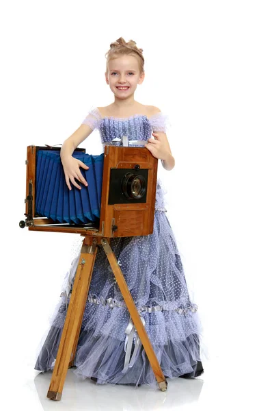 Niña posando cerca de la vieja cámara . —  Fotos de Stock