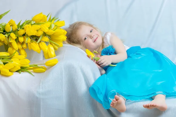 Дівчинка з жовтими тюльпанами . — стокове фото