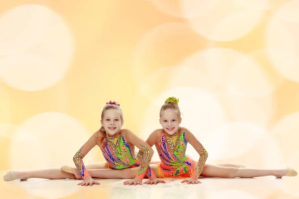 Two girls gymnast sitting on splits. — Stock Photo, Image