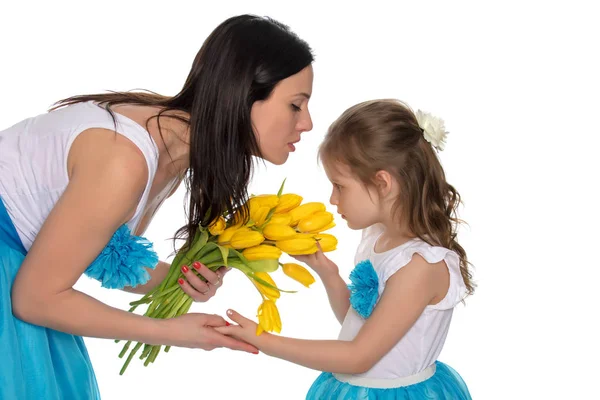 Мать и дочь пахнут желтыми тюльпанами . — стоковое фото