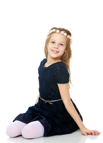 Schönes kleines Mädchen posiert sitzend auf dem Boden. — Stockfoto