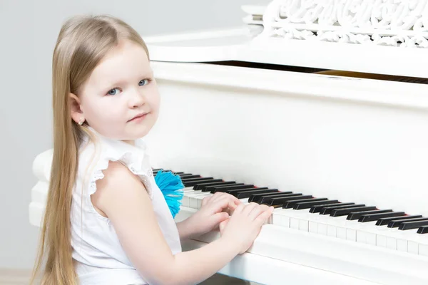 Маленькая девочка играет на пианино . — стоковое фото