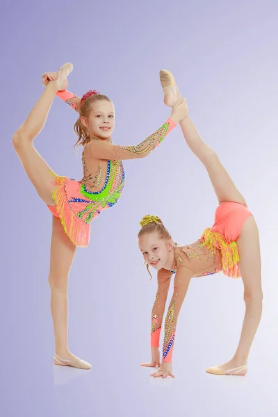 Dos chicas gimnasta sentado en splits . —  Fotos de Stock