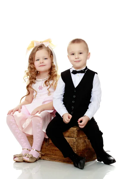 Boys girls sit on old trunk. — Stock Photo, Image