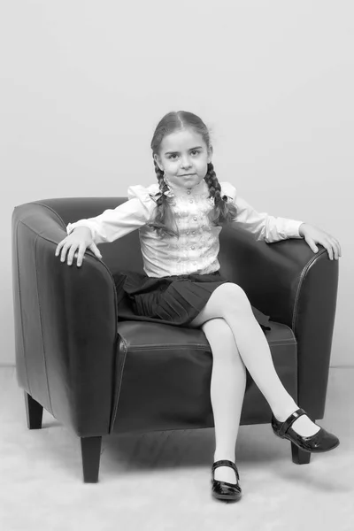 Ένα κοριτσάκι κάθεται σε μια καρέκλα. — Φωτογραφία Αρχείου