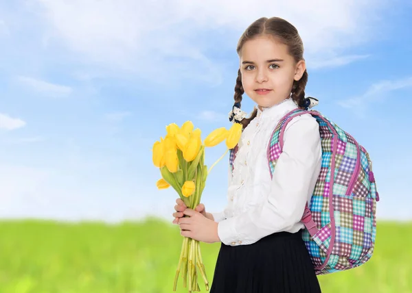 Uczennica z bukietem kwiatów i plecak na jej sho — Zdjęcie stockowe