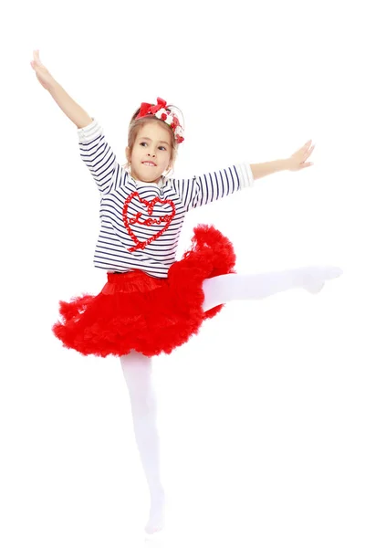 Little girl in a red skirt and bow on her head. — Stock Photo, Image