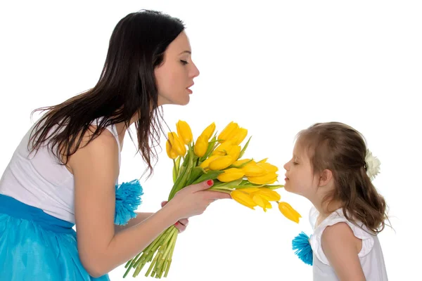 Mamma och dotter njuter av doften av blommor. — Stockfoto