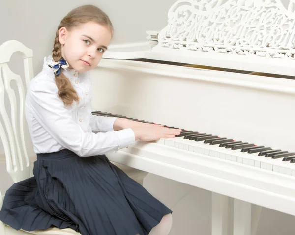Uma menina de uma escola de música toca piano . — Fotografia de Stock