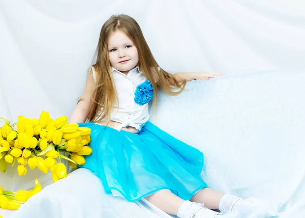 Kleines Mädchen mit einem Strauß Tulpen — Stockfoto