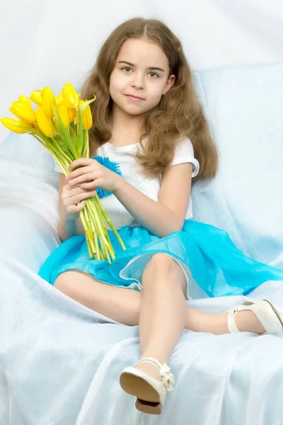 Bella studentessa bionda con tulipani gialli seduta sul cou — Foto Stock