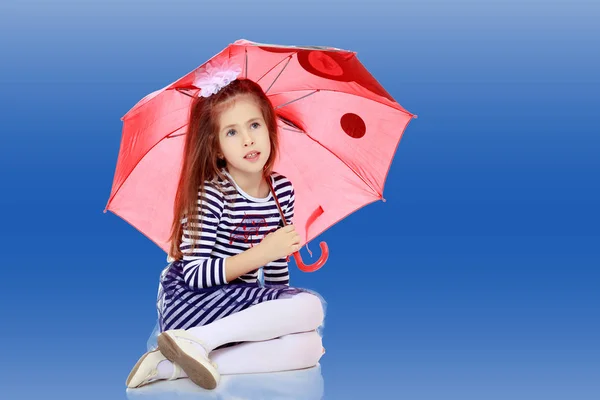 Kleines Mädchen versteckt sich unter einem Regenschirm. — Stockfoto