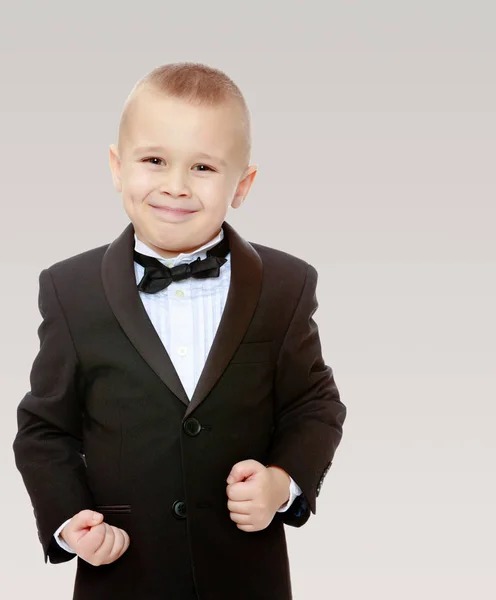 Trendy little boy in a black suit with a tie. — Stock Photo, Image