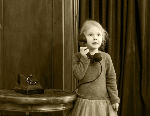 Девочки звонят по старому телефону . — стоковое фото