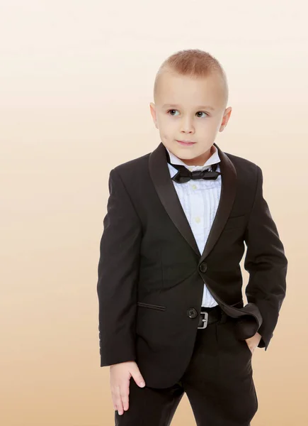 Модний маленький хлопчик в чорному костюмі з краваткою . — стокове фото