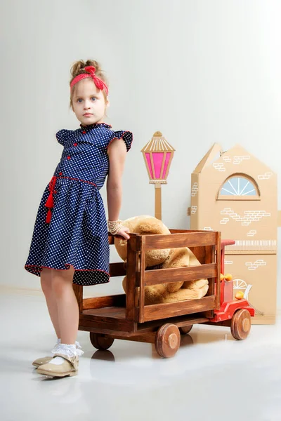 Bambina che gioca con una grande macchina di legno . — Foto Stock