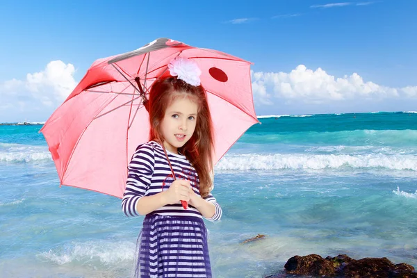 Kleines Mädchen versteckt sich unter einem Regenschirm. — Stockfoto