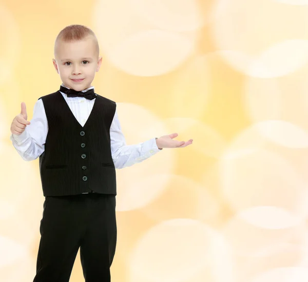 Trendy kleine jongen in een zwart pak met een stropdas. — Stockfoto