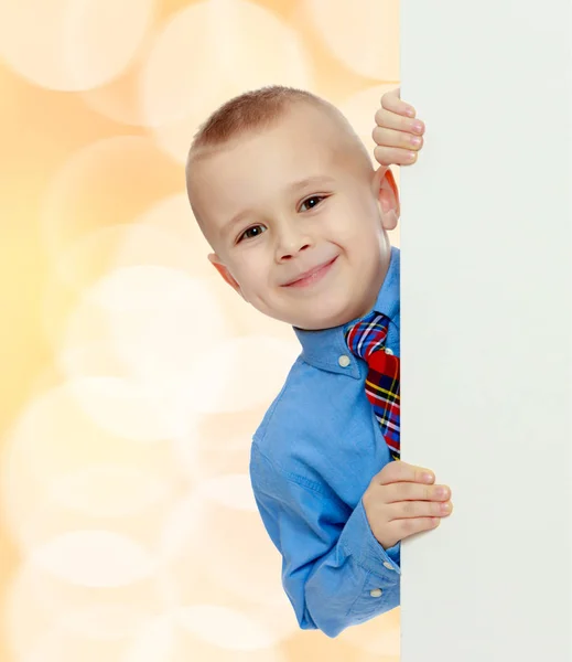 Jongen gluurt uit achter de banner — Stockfoto