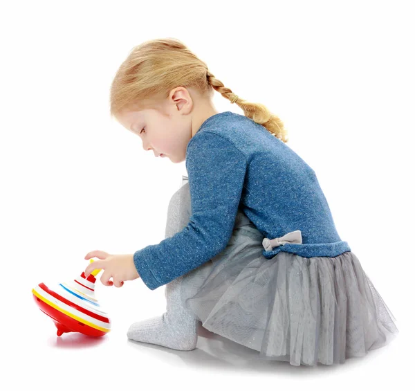 Girl playing humming top. — Stock Photo, Image