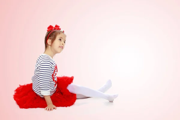 Dziewczynka w czerwonej spódnicy i kokardkę na głowie. — Zdjęcie stockowe