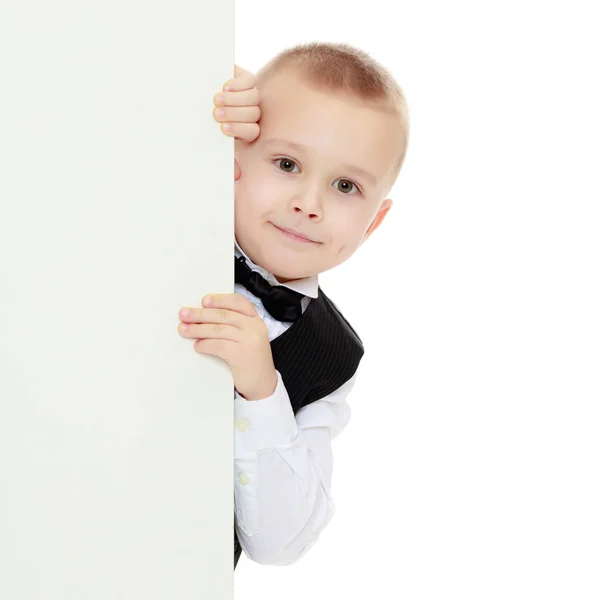 Мальчик подглядывает за белым плакатом . — стоковое фото