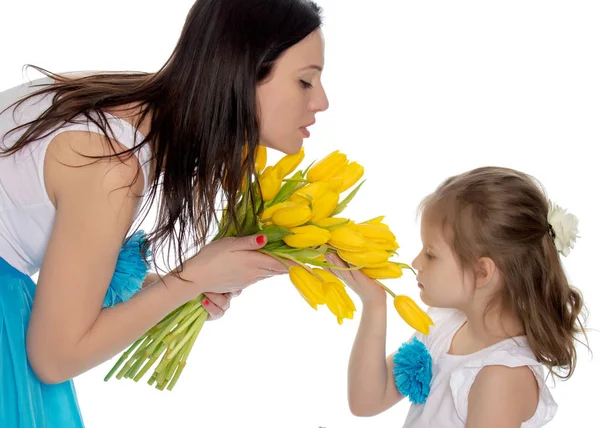 Mãe e filha desfrutando a fragrância das flores . — Fotografia de Stock