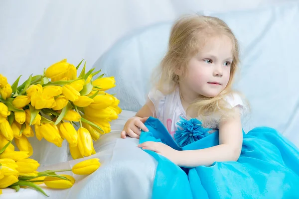 Bambina con tulipani gialli . — Foto Stock