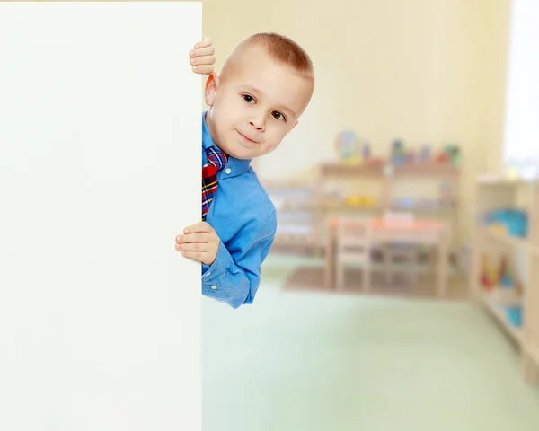 Boy peeks out from behind the banner — Stock Photo, Image