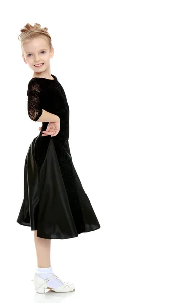 Schöne kleine Tänzerin in einem schwarzen Kleid. — Stockfoto