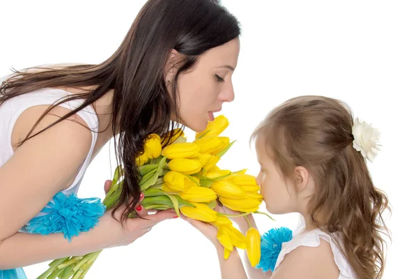 Madre e figlia che odorano di tulipani gialli . — Foto Stock