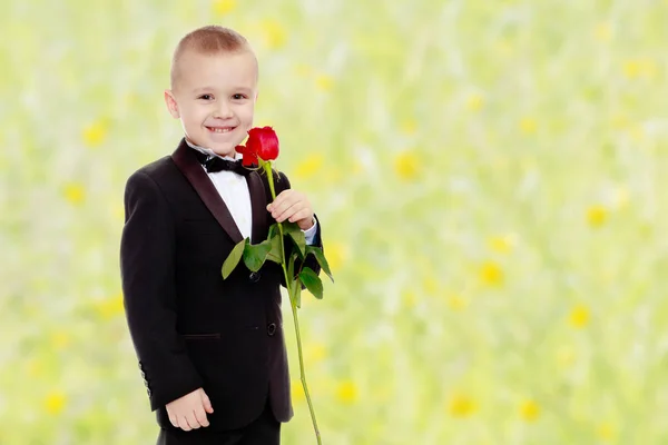 Mały chłopiec z róży kwiat. — Zdjęcie stockowe