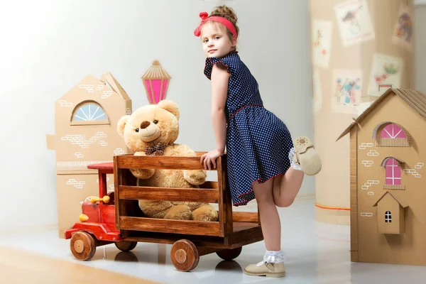Bambina che gioca con una grande macchina di legno . — Foto Stock