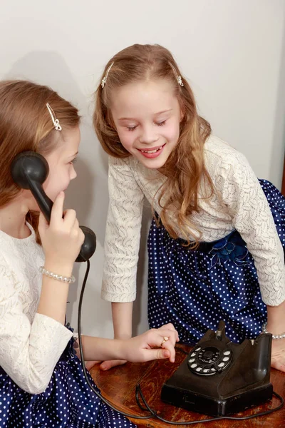 Dua saudara perempuan berbicara di telepon lama — Stok Foto