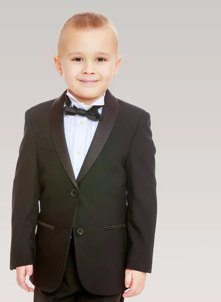 Trendy little boy in a black suit with a tie. — Stock Photo, Image