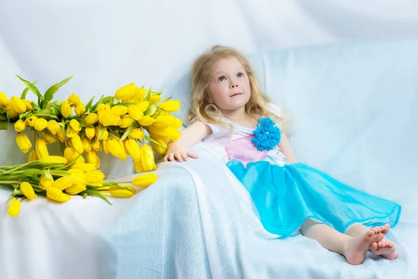 Дівчинка з жовтими тюльпанами . — стокове фото