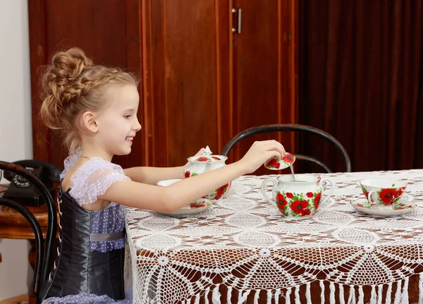 Petite fille mignonne buvant du thé à la vieille table . — Photo