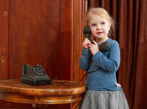 The girls ringing on the old phone. — Stock Photo, Image