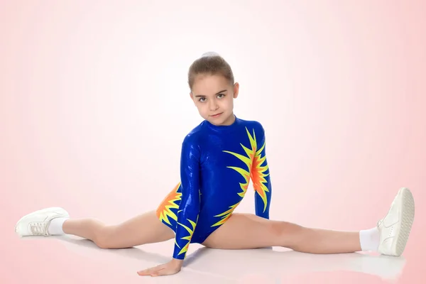 Una chica gimnasta en edad escolar hace un cordel . —  Fotos de Stock