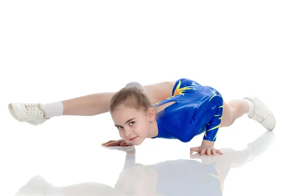 Une fille gymnaste effectue des exercices sur le sol . — Photo