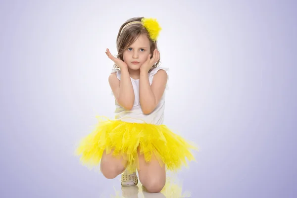 Küçük kız bir sarı etek ve beyaz t-shirt. — Stok fotoğraf